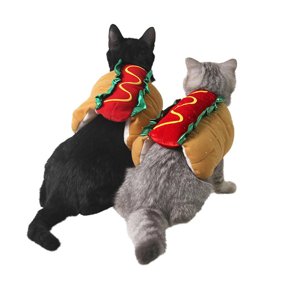 A black cat and a gray cat wearing cozy hot dog costumes with red and yellow accents.