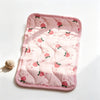 A pink quilted self-cooling pet mat for dogs and cats with a pattern of red apples.