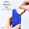 A hand is filling a blue cat scratcher brush with dried mint to attract cats.