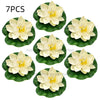 A set of seven white lotus flowers resting on green water lily pads.