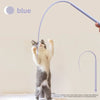 A cat is interacting with a blue silicone toy that resembles a mouse tail.
