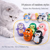A gray cat is positioned next to a collection of ten randomly selected, colorful, self-rolling pet toys.