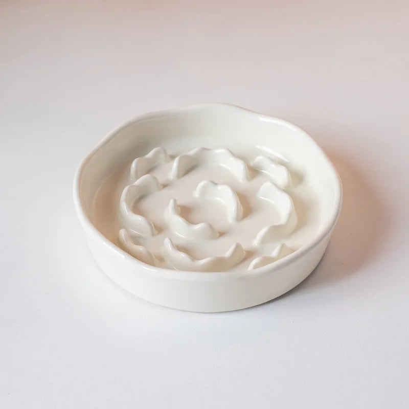 A white ceramic pet bowl with a raised neck design filled with a white substance.