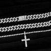 A set of dainty diamond Cuban link necklaces and a cross pendant displayed on black velvet.