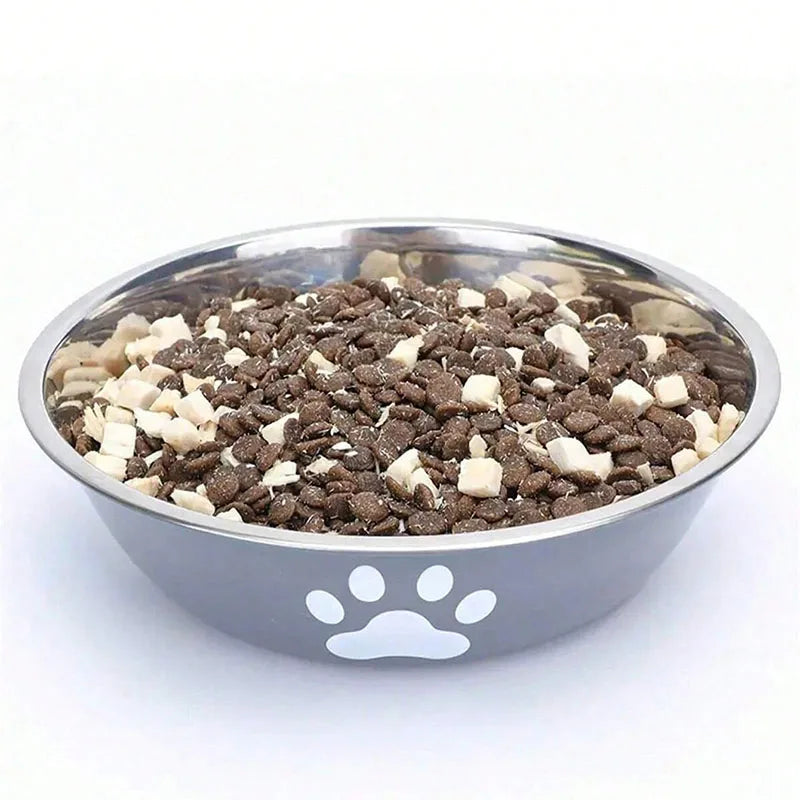 Stainless steel pet bowl filled with dark kibble and white pieces on a white background