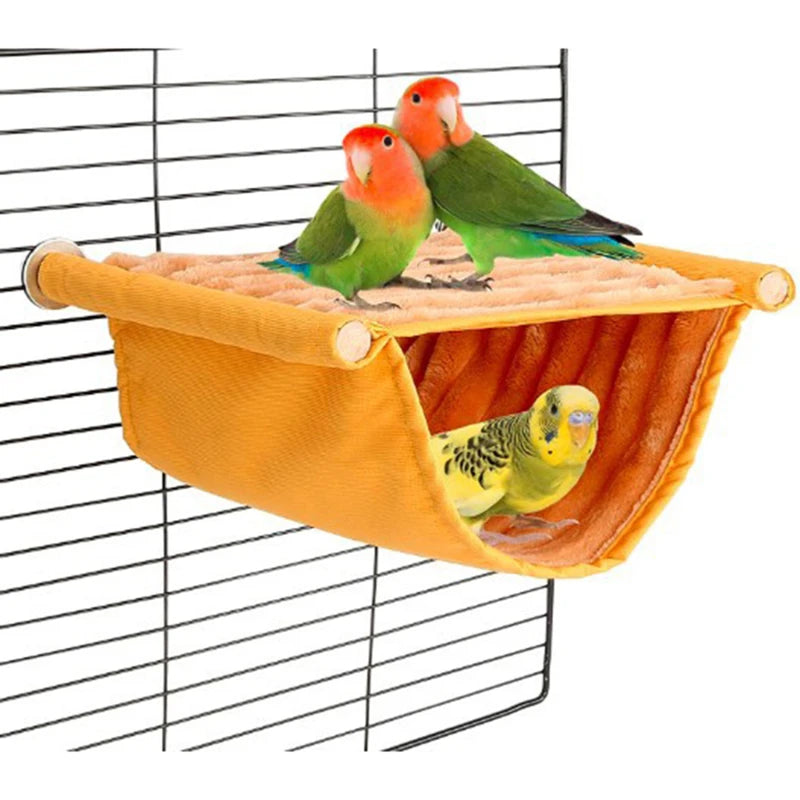 A cozy orange fleece bird hammock holding two small, colorful parrots inside a wire cage.