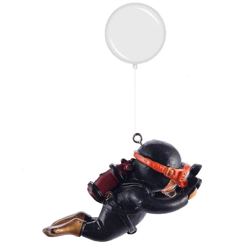 A resin mini diver ornament with a black body and orange accents is suspended by a white balloon.