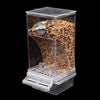 Clear acrylic automatic bird feeder with a perch filled with seeds.