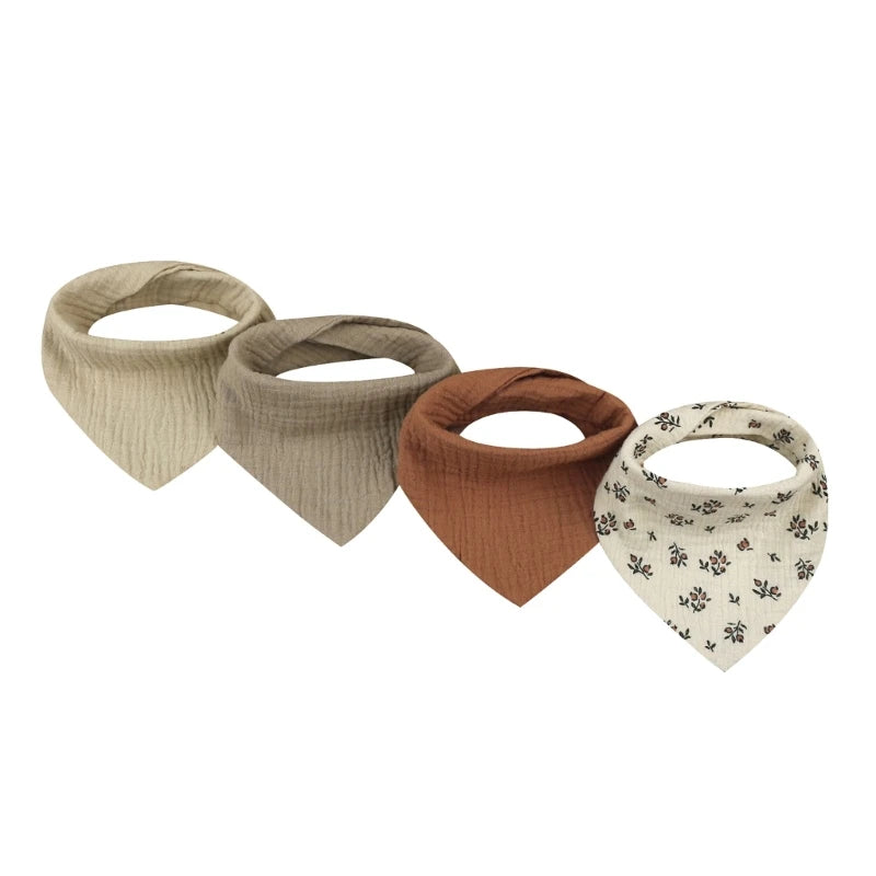 A set of four beige and terracotta cotton baby bibs with various printed designs for newborns.
