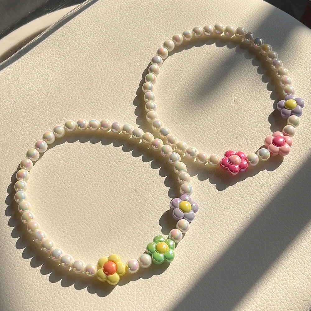 A set of pastel floral beaded necklaces, featuring pink, purple, and yellow beads.