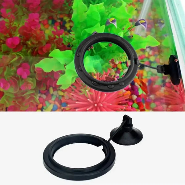 Anillo de alimentación para acuario negro con ventosas, mostrado contra un fondo de plantas coloridas.