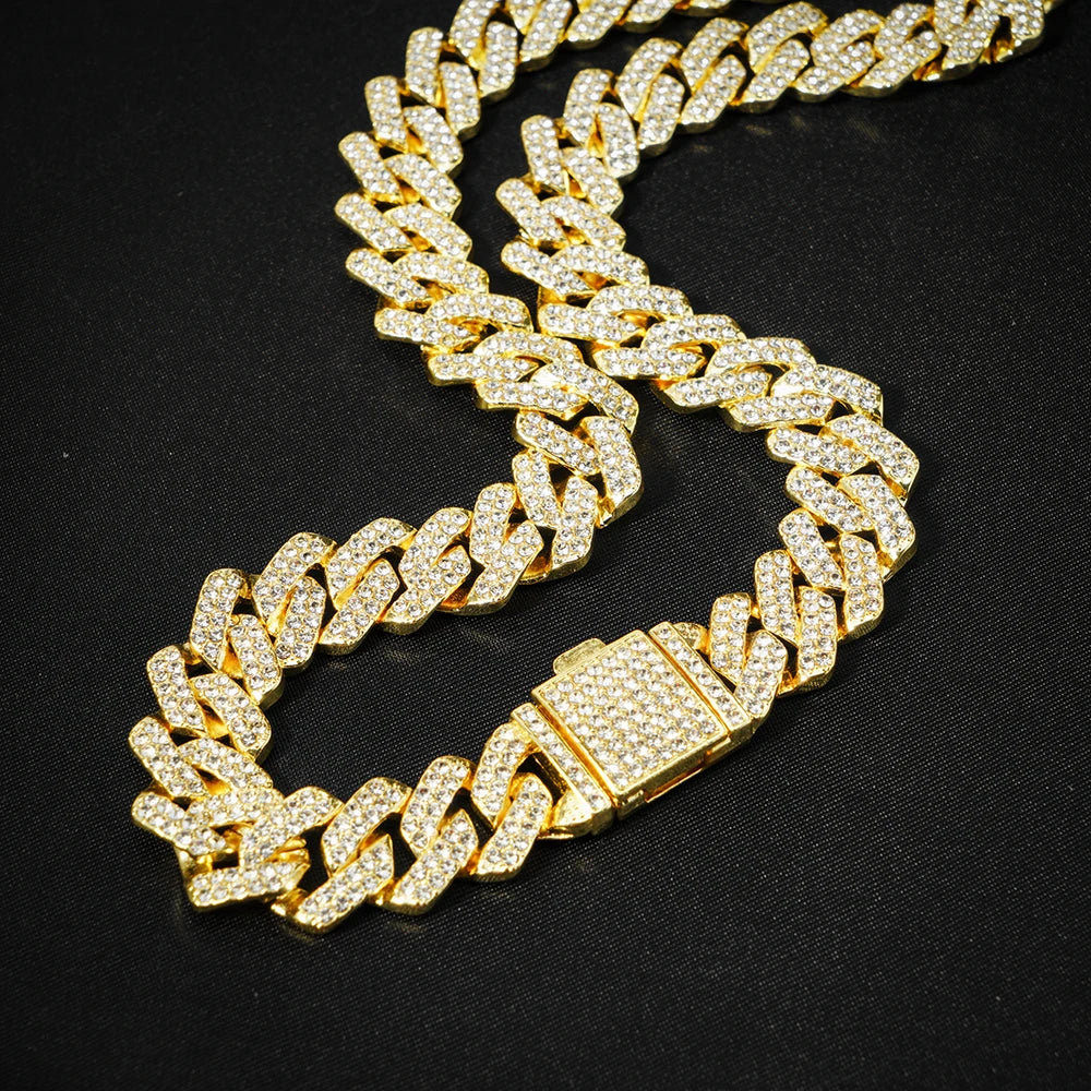 Collier à maillons cubains en or avec diamants pavés sur fond noir.