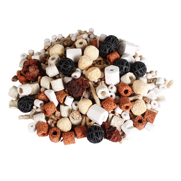 A pile of aquarium bio filter media consisting of various sizes and shapes including ceramic rings, activated carbon, and por