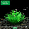 Une plante aquatique artificielle vert vif est plantée dans du gravier foncé pour décoration d'aquarium.