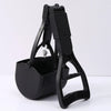A black foldable pet poop scooper with a handle and container is shown on a white surface.