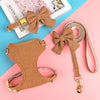 Braunes gestricktes Hundehalsband und Leine-Set mit verzierten Schleifchen auf rosa Hintergrund.