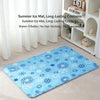 A blue ice mat with snowflake patterns is displayed on a light carpet next to a white shelving unit.