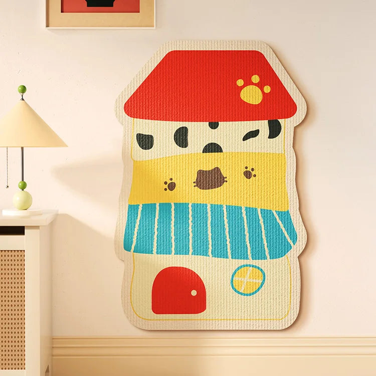 A felt cat scratch board shaped like a cat's face with a red hat and yellow features mounted on a wall.