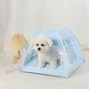 Un lit de tente pour animal de compagnie bleu clair avec tissu transparent et garniture décorative, contenant un chien blanc 