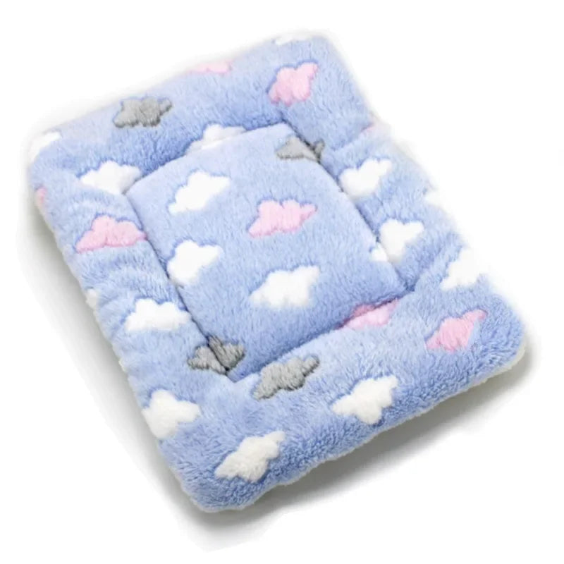 A light blue plush fleece pet blanket or bed mat with white and pink cloud patterns.