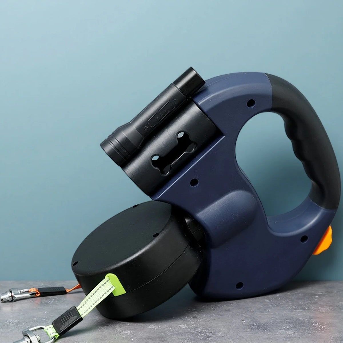 A dark blue retractable dog leash with a black handle and an LED light is shown against a light blue background.