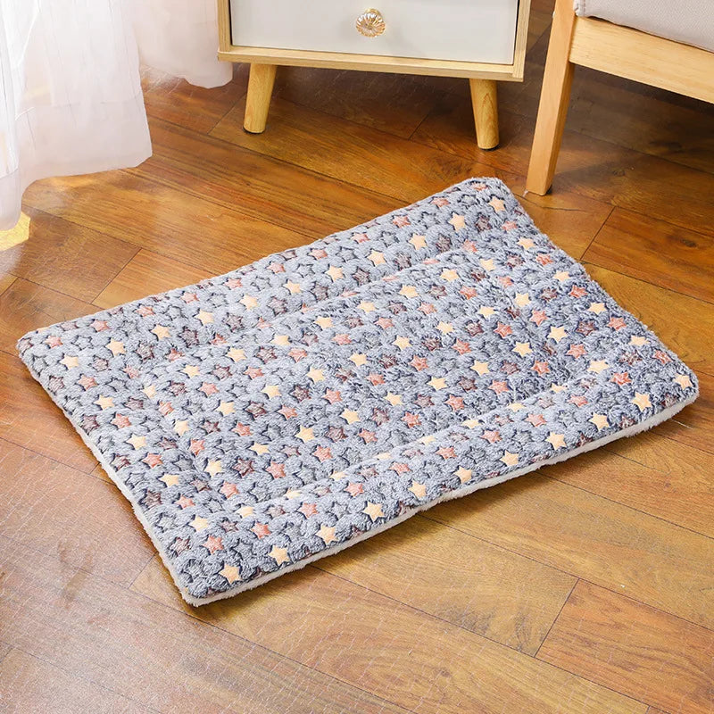 Un lit pour animal de compagnie rectangulaire et douillet en flanelle, à motifs floraux gris et orange, posé sur un plancher 