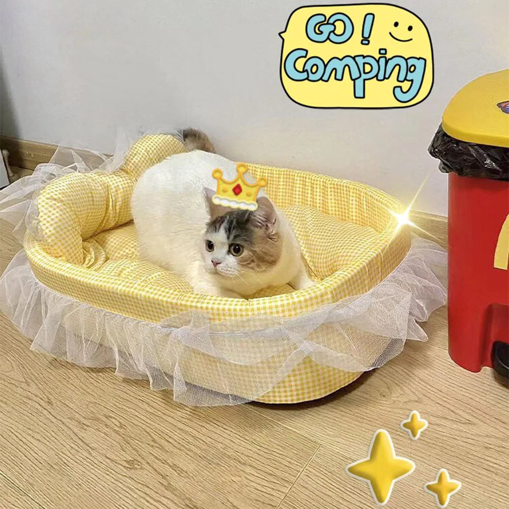 A fluffy white and gray cat wearing a crown is relaxing in a yellow lace-trimmed plush pet sofa bed.