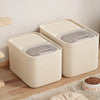 A beige airtight pet food storage container with a clear lid is shown on a wooden floor.