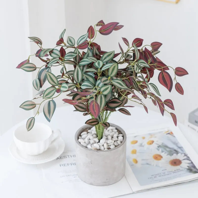 Artificial bonsai tree with variegated green and reddish leaves potted in a gray ceramic container