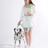 A woman holds an adjustable hands-free dog leash with a green and light blue cord, standing next to a dog.