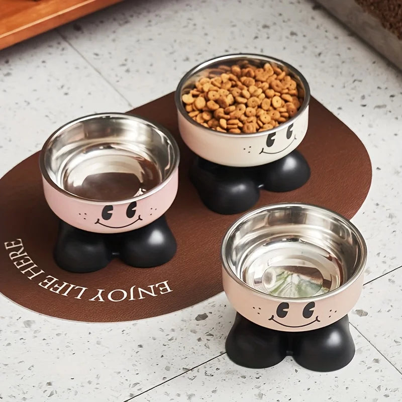 A set of pink and black elevated stainless steel pet feeders with a no-spill design, featuring dry kibble.