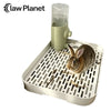 A small brown rabbit is using a clear pet litter box dispenser on a white tray.