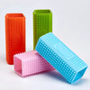 A collection of silicone pet hair remover brushes in orange, green, and blue.