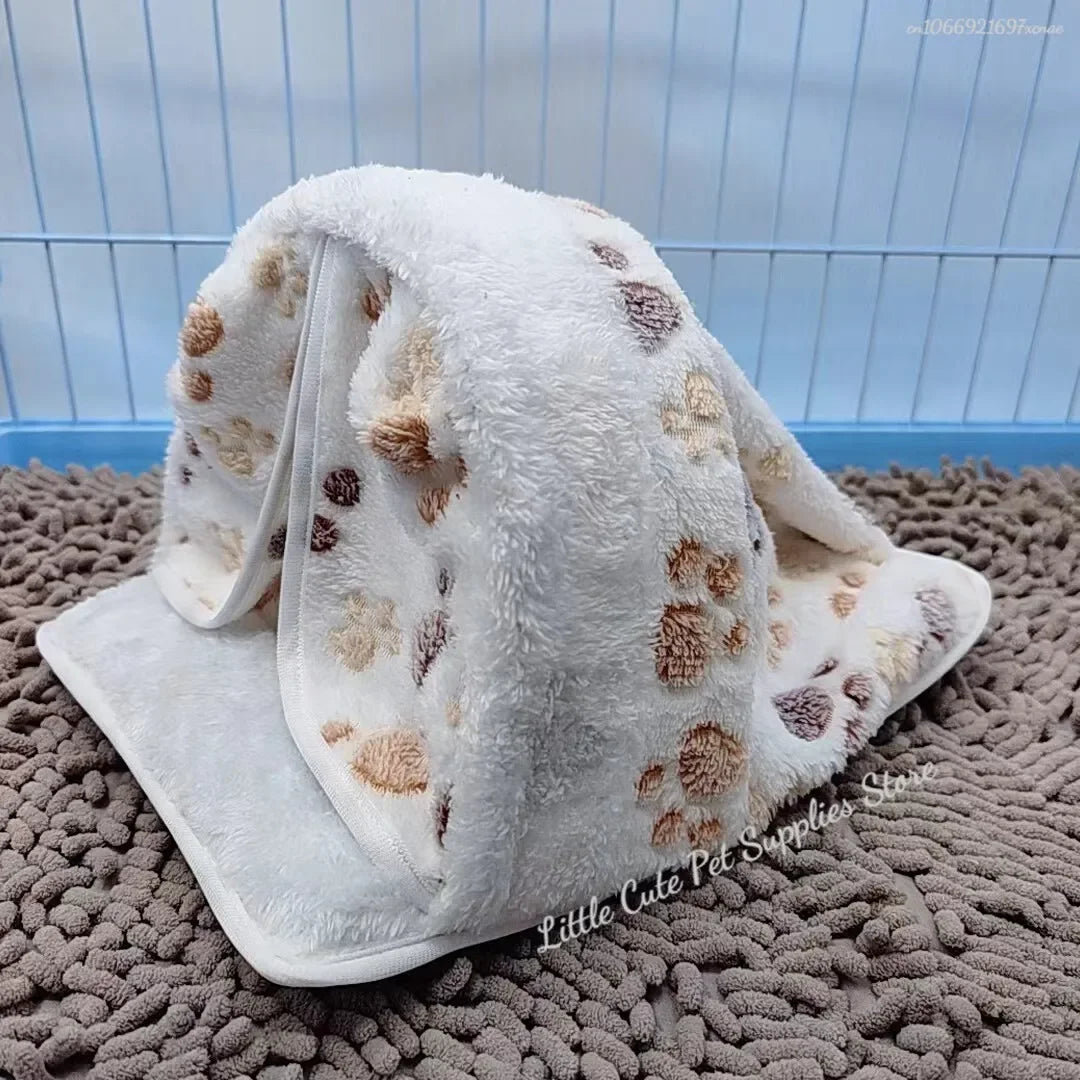 Hamaca de mascota blanca y esponjosa con manchas marrones, mostrada sobre una superficie marrón texturizada.