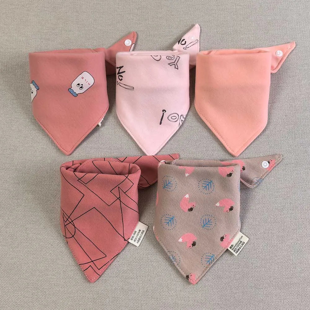 A set of five pink cotton triangle baby bibs featuring various cartoon prints and designs.