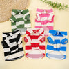 A collection of children's striped polo shirts in green, pink, and blue, laid out on a light background.