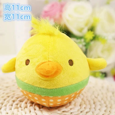 A yellow plush squeaker toy shaped like a duck with orange beak and green belly, resting on a knitted surface.