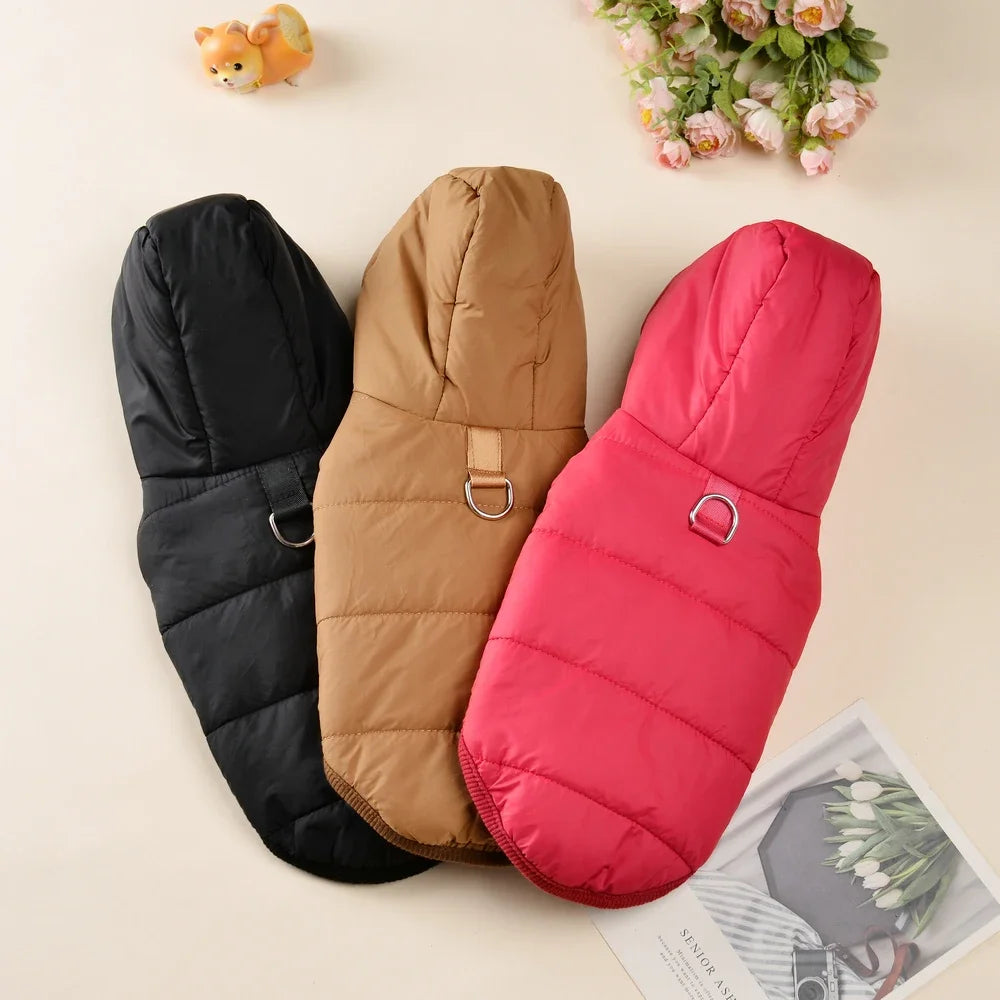Trois sweats à capuche en polaire pour chiens noirs, beige et rose présentés sur un fond clair.