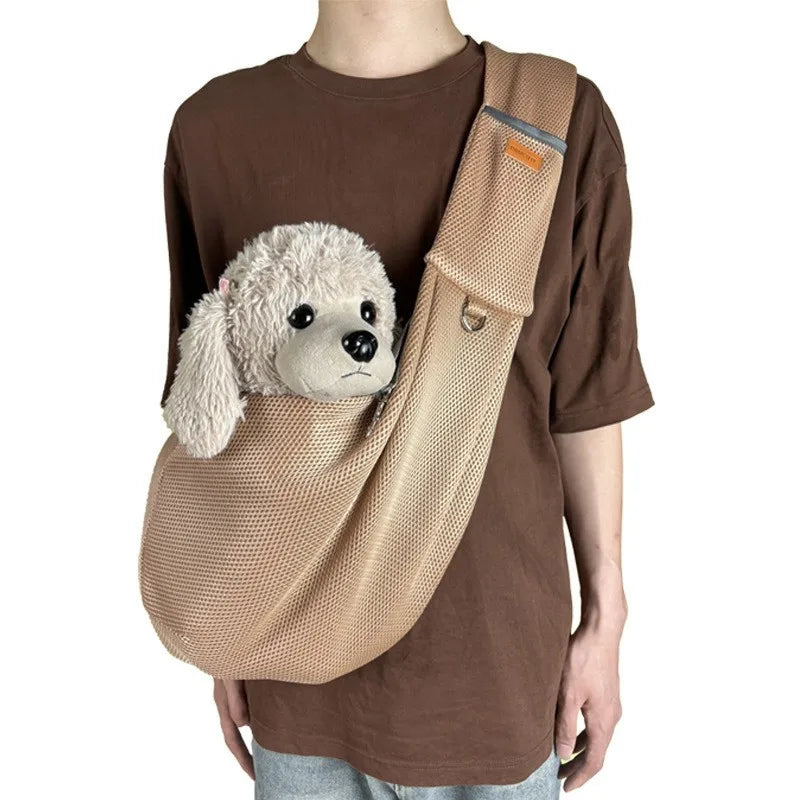 A brown t-shirt features a beige breathable mesh dog carrier crossbody bag with a fluffy white dog head attached.