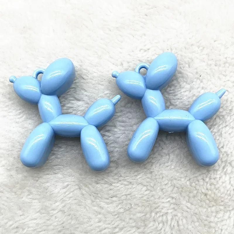 A pair of light blue acrylic balloon dog charm pendants for jewelry making and keychains.