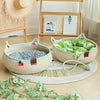 A beige woven cat scratcher and comfort bed with green and white fabric and colorful play balls on a light wood floor.