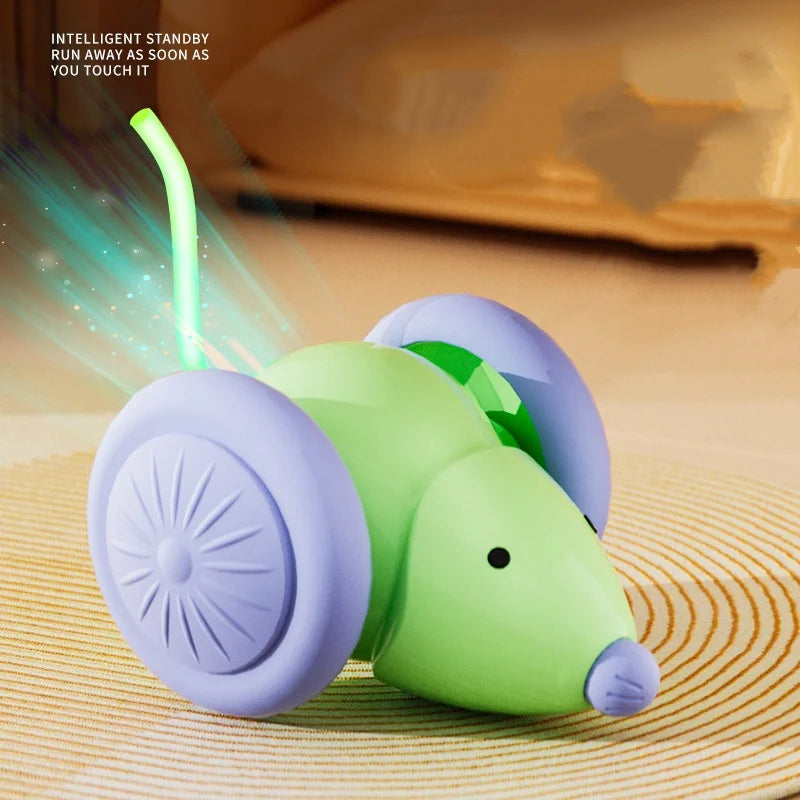 A green and purple interactive rotating feather cat toy is shown with a light beam emanating from it.