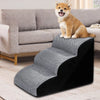 A fluffy orange chihuahua dog is sitting on a gray and black memory foam pet ramp for dogs.