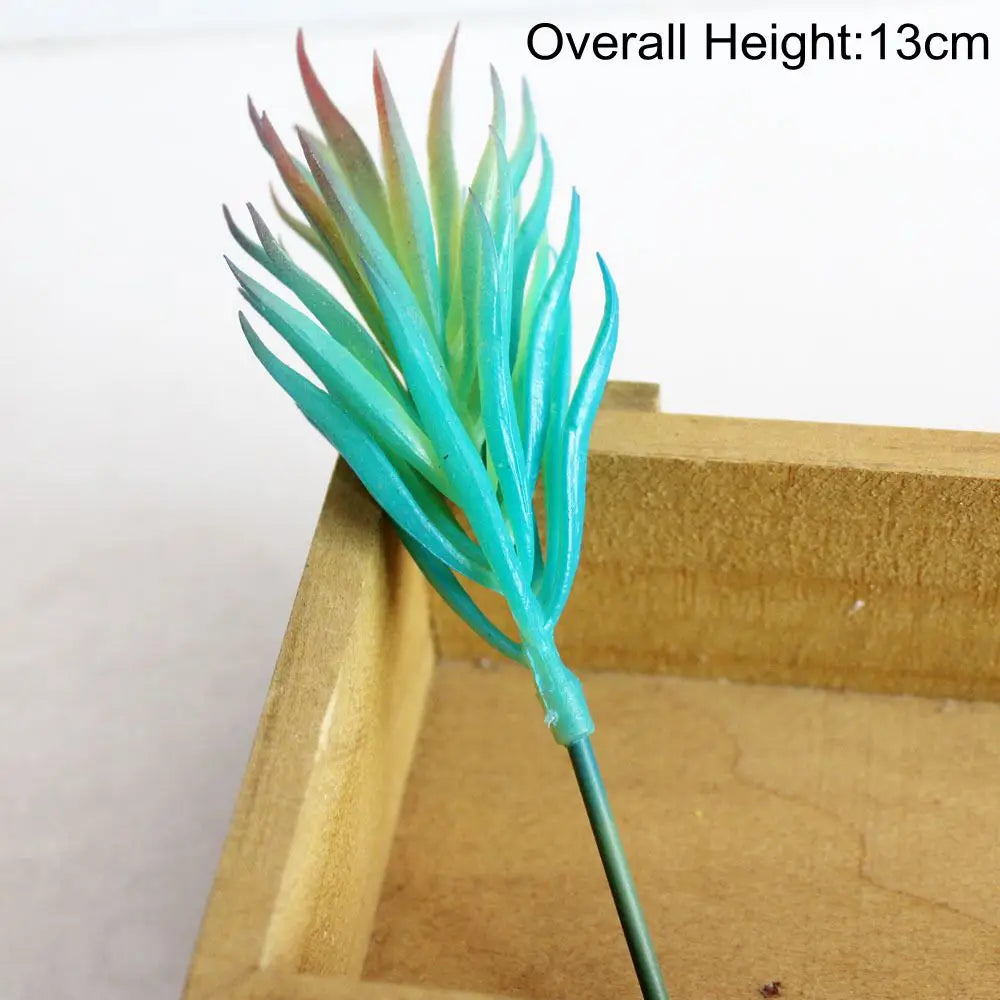 A vibrant blue artificial succulent plant with spiky leaves is displayed in a wooden tray.
