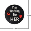 Black embroidered patch with white text I'm Working For HER and a red paw print.
