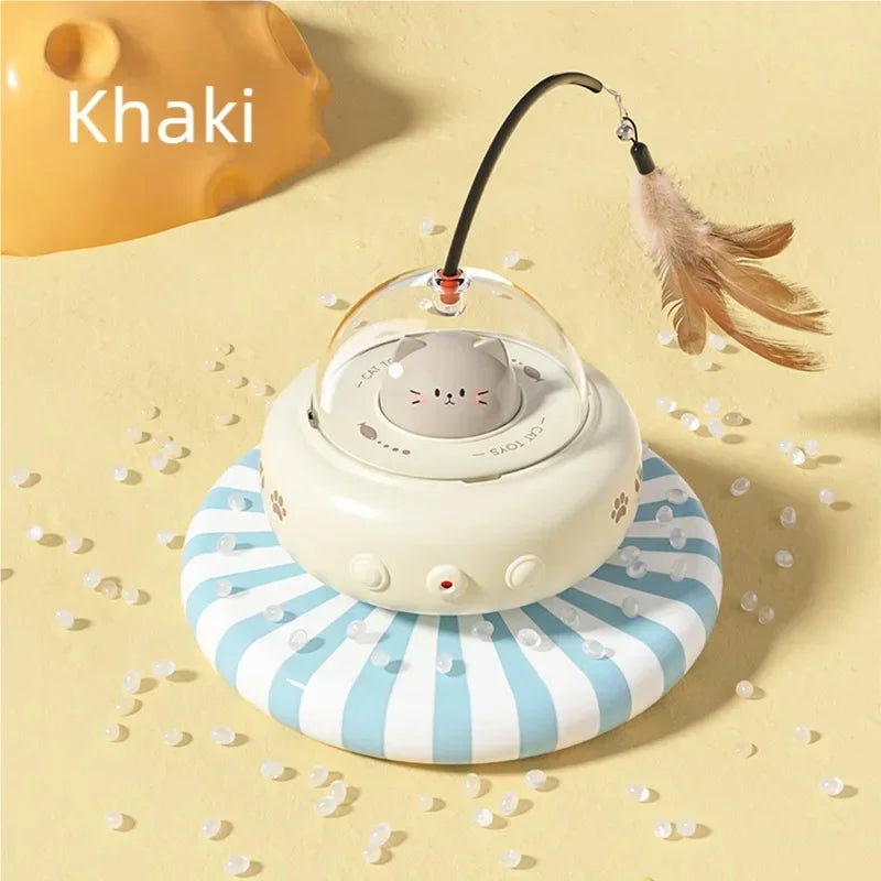 A white automatic UFO cat teaser toy with a feather wand resting on a striped surface.