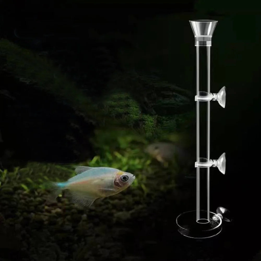 Adjustable aquarium feeder with a transparent tube and a small fish in a dark, mossy environment.