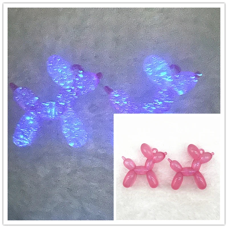 A pair of pink acrylic balloon dog charms used for jewelry making or keychains.