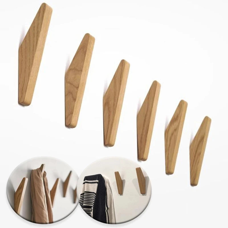 Three wooden coat hooks mounted on a wall, showing the natural grain of oak wood.