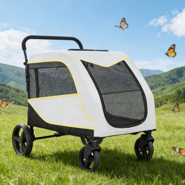 A white and black all-terrain dog stroller is shown outdoors on a grassy field with mountains in the background.